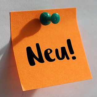 Orangenes Post-It mit der Aufschrift "Neu"