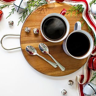 Zwei Tassen mit schwarzem Kaffee stehen auf einem weihnachtlich gedeckten Tisch
