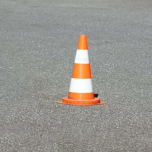 Ein Warnkegel auf Asphalt