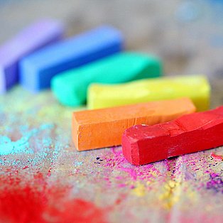 Bunte Kreidestifte liegen auf einer Pappunterlage
