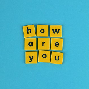 Auf gelben Spielsteinen steht die Frage: How are you?