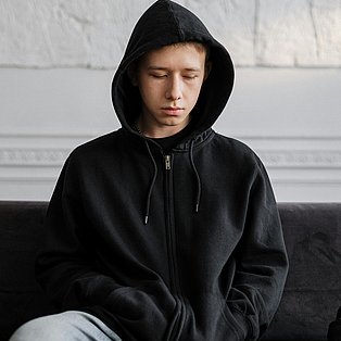 Jugendlicher mit Kapuzenpulli wirkt traurig